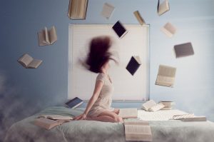 Kobieta z książkami na łóżku
